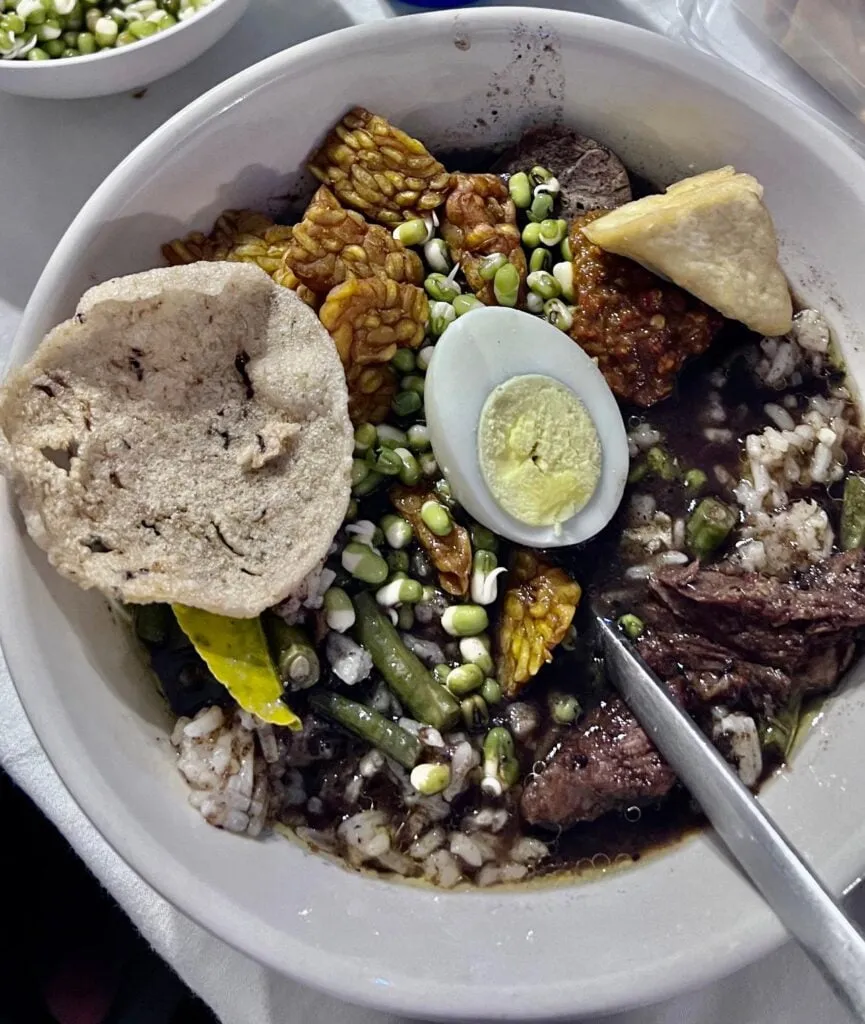 Traditional Javanese rawon soup served with rice and garnishes